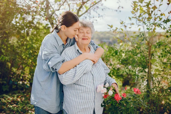 Old Woman Holding Flowers Woman Blue Shirt Grandmother Granddaughter — Foto de Stock