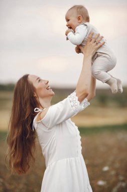 Anne ve kızı. Tarlada bir aile. Yeni doğmuş kız. Beyaz elbiseli kadın..