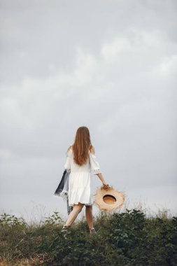 Woman in a summer field. Lady in a white dress. Girl on a sunset background.