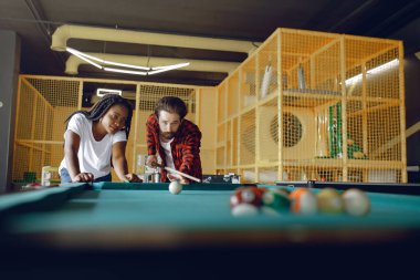 Beyaz tişörtlü siyah kız. Bilardo oynayan bir çift