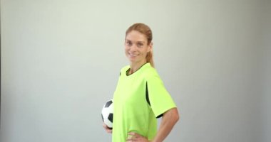 Arka planda futbol topuyla duran genç bayan futbolcu. Futbol konsepti, şampiyonluk..