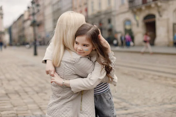 Mladá Matka Objímá Svou Dceru Dívka Tváři Namalovanou Vlajku Ukrajiny — Stock fotografie