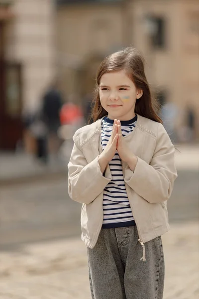 Mała Dziewczynka Ukraińską Flagą Policzku Stojąca Ulicy Młoda Ślicznotka Modli — Zdjęcie stockowe