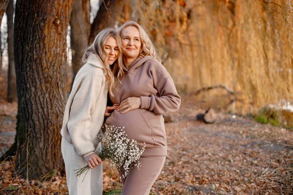 Adult Daughter Hugs Her Pregnant Mom Sunny Autumn Day Nature — Fotografie, imagine de stoc