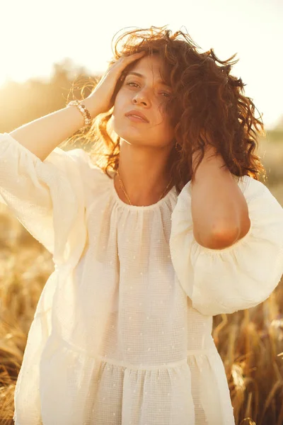 Yaz tarlasında bir kadın. Beyaz gömlekli esmer. Günbatımı geçmişinde bir kız.