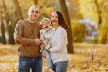 Küçük tatlı kızı olan bir aile. Kahverengi kazaklı baba. Sonbahar tarlasında bir aile