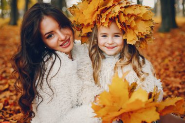 Güzel bir anne ve kızı. Sonbahar parkında bir aile. Altın sonbahar