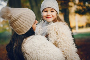 Güzel bir anne ve kızı. Sonbahar parkında bir aile. Altın sonbahar