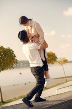 Deniz kenarında bir çift. Siyah şapkalı adam. Günbatımı arka planında eşleşin.