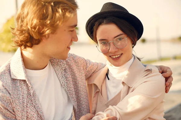 Deniz kenarında bir çift. Siyah şapkalı adam. Günbatımı arka planında eşleşin.