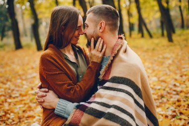 Parkta bir çift. Kahverengi kazaklı kadın. Sakallı adam.