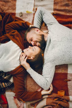 Parkta bir çift. Kahverengi kazaklı kadın. Sakallı adam.