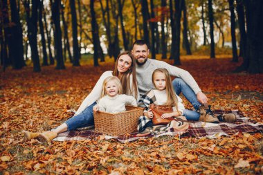 Sonbahar parkında bir aile. Kırmızı kazaklı kadın. Ebeveynleri olan sevimli çocuklar.