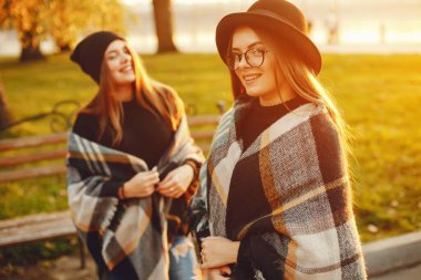 Güneşli yaz şehrinde yürüyen iki şık genç kız