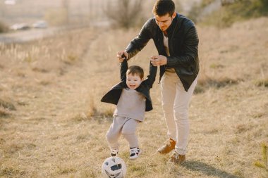 Bir bahar tarlasında aile. Beyaz kazaklı baba. Toplu şirin bir oğlan..