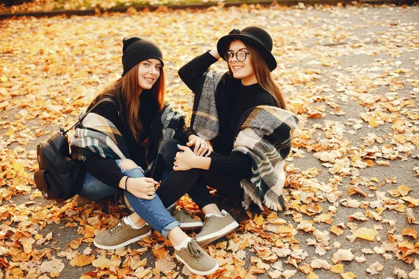 Dwie Młode Stylowe Dziewczyny Siedzące Jesiennym Mieście — Zdjęcie stockowe