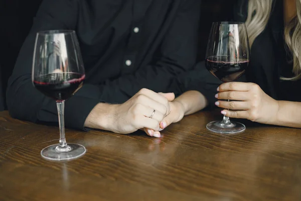 Man and woman relax, couple hugs in bar. Drinking wine.