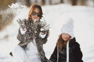 Family on family Christmas vacation. Woman and little girl in a forest. People walks.