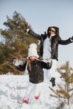 Family on family Christmas vacation. Woman and little girl in a forest. People walks.