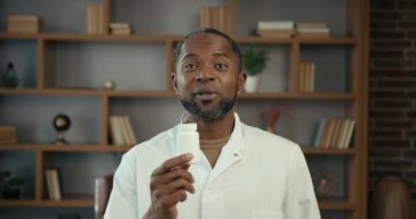 Eczacı elinde bir şişe hap tutuyor. Tıp konseptinin reklamı.
