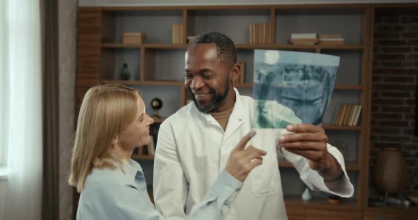 Черный Мужчина Белая Женщина Коллеги Осматривающие Пациентов Сообщают Опытный Стоматолог — стоковое видео