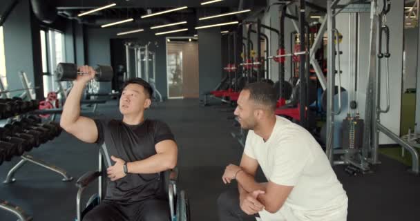 코치와 휠체어에 장애인 전문가는 휠체어를 운동하는 남자를 돕습니다 — 비디오