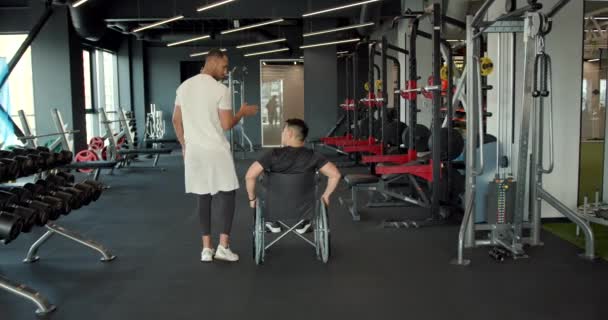 Niepełnosprawny Wózku Ćwiczy Trenerem Specjalista Rehabilitacji Pomaga Facetowi Wózku Ćwiczyć — Wideo stockowe