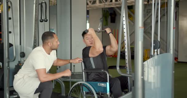 坐轮椅的残疾人和教练一起工作 康复专家帮助坐轮椅的人做运动 — 图库视频影像