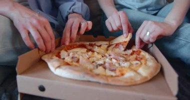 Pizza yiyip mutfakta oturan iki mutlu genç kız. Lgbtq çifti birlikte yaşıyor..