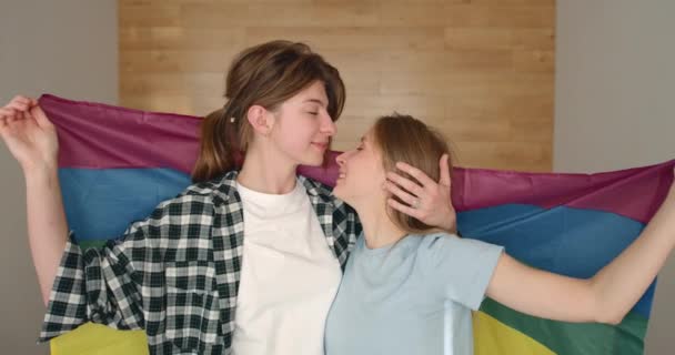 Cuplu Fete Lesbiene Tinere Împotriva Unui Steag Curcubeu Îmbrățișându Fericit — Videoclip de stoc