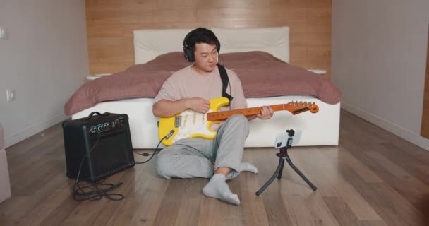 Счастливый Молодой Человек Вдохновленный Игрой Гитаре Записывает Собственное Аудио Выступление — стоковое видео