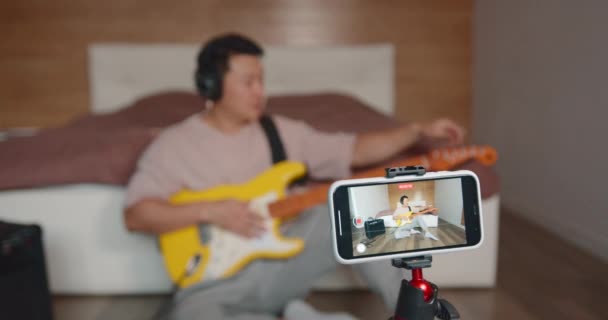 Szczęśliwy Młody Inspirowany Człowiek Gra Gitarze Nagrywając Własną Wydajność Audio — Wideo stockowe