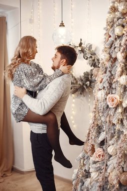 Noel süsü takmış insanlar. Gri kazaklı adam. Aile evde..