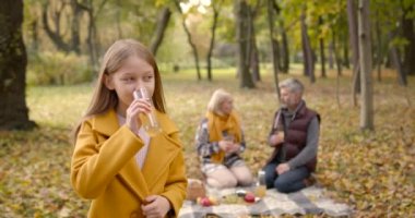 Boş zaman ve insan konsepti - büyükanne ve torun sonbahar ormanlarında piknik yapıp çay içiyorlar..