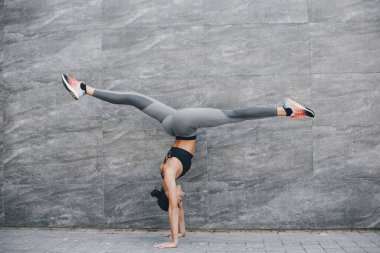 Yaz şehrinde güzel bir bayan antrenmanı. Esmer, yoga yapıyor. Spor kıyafetli bir Gitl.