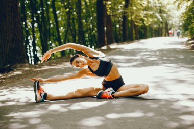 Bir yaz parkta eğitim hoş bir bayan. Yoga yaparken esmer. Siyah top bir kız