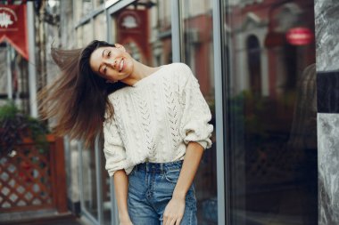 Şehirde güzel bir kız. Beyaz kazak şık kız