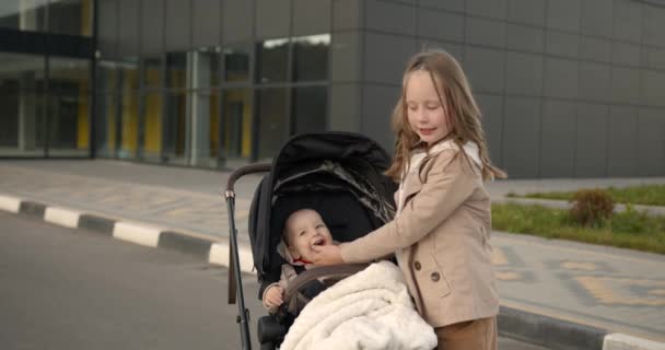 Äldre Syster Kramas Med Sin Nyfödda Syster Barnvagn Allmän Park — Stockvideo