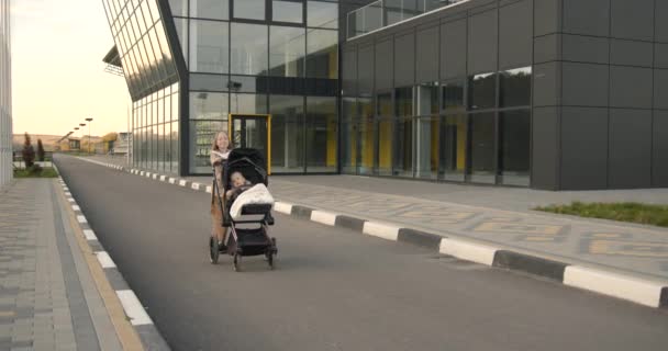 Die Ältere Schwester Kuschelt Mit Ihrer Neugeborenen Schwester Kinderwagen Öffentlicher — Stockvideo