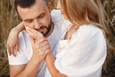 Tarlada sevimli bir çift. Beyaz bluzlu bir kadın. Beyaz gömlekli adam.