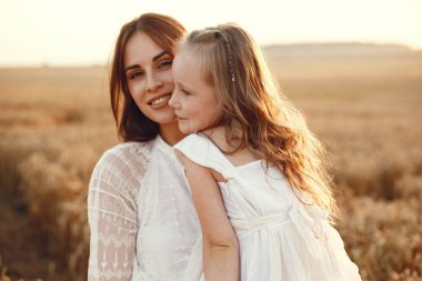 Yaz tarlasında bir aile. Şehvetli bir fotoğraf. Sevimli küçük kız. Beyaz elbiseli kadın..