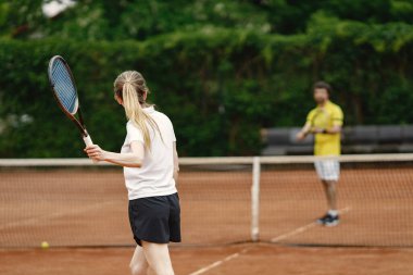 Photo of male and female tennis players during game. Couple playing a match. Man wearing yellow t-shirt and woman the white one.