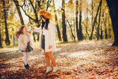 Güzel bir anne ve kızı. Sonbahar parkında bir aile. Altın sonbahar