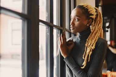 People and leisure concept. Headshot of beautiful African girl. Woman in a gray sweater.