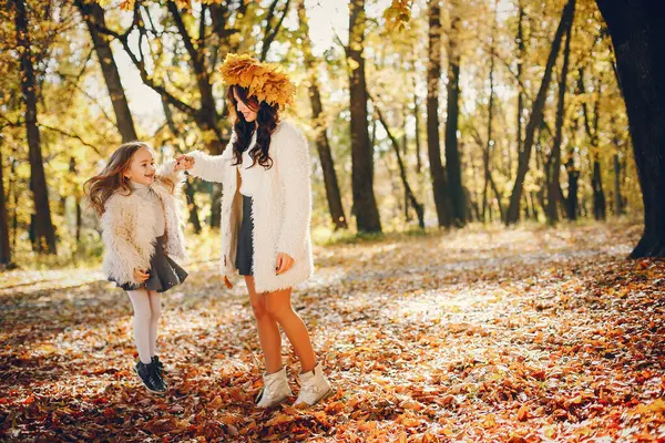 Güzel bir anne ve kızı. Sonbahar parkında bir aile. Altın sonbahar