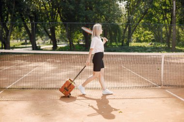 Tenis oyuncusu tenis papyonundan geçiyor. Model pozu. Hobiler, spor, ekipmanlar.