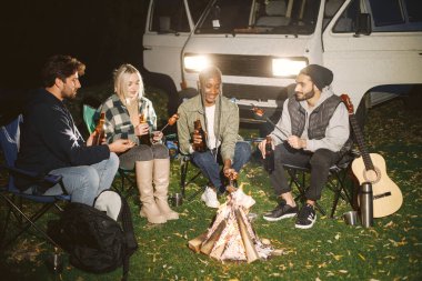 Gitar çalan Müslüman bir adam, arkadaş listesi. Gençler sonbaharda piknikte eğlenirler..