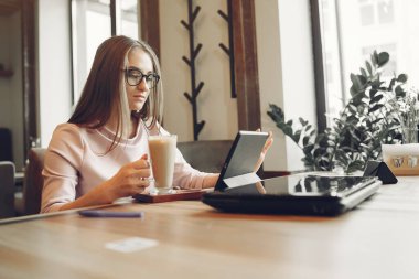 Woman working at the office. Lady with a tablet. Woman in a white blouse.