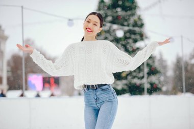 Kış şehrinde duran tatlı kız. Beyaz kazaklı kadın..