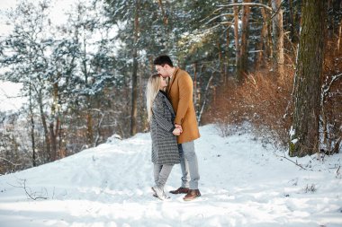 karlı bir günde parkta yürüyen mutlu genç çift